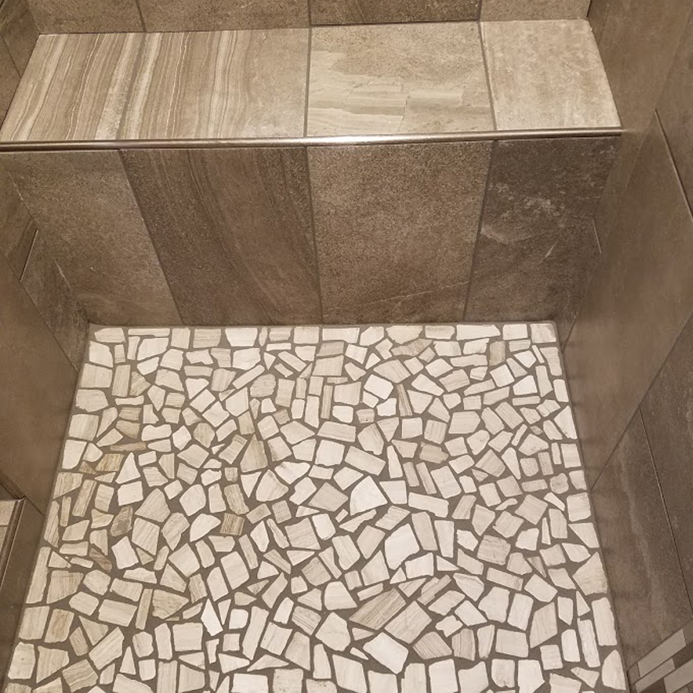 Stone mosaic shower floor with custom built shower bench Stone mosaic shower floor with custom built shower bench